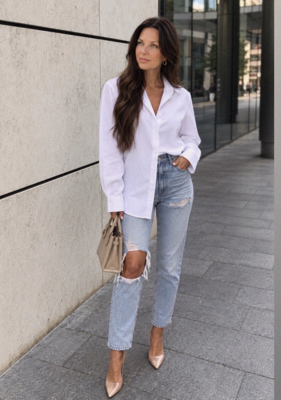 Brennan Quigley in a white shirt and jeans, walking downtown
